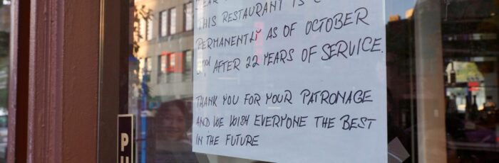 A sign posted on the door of a restaurant