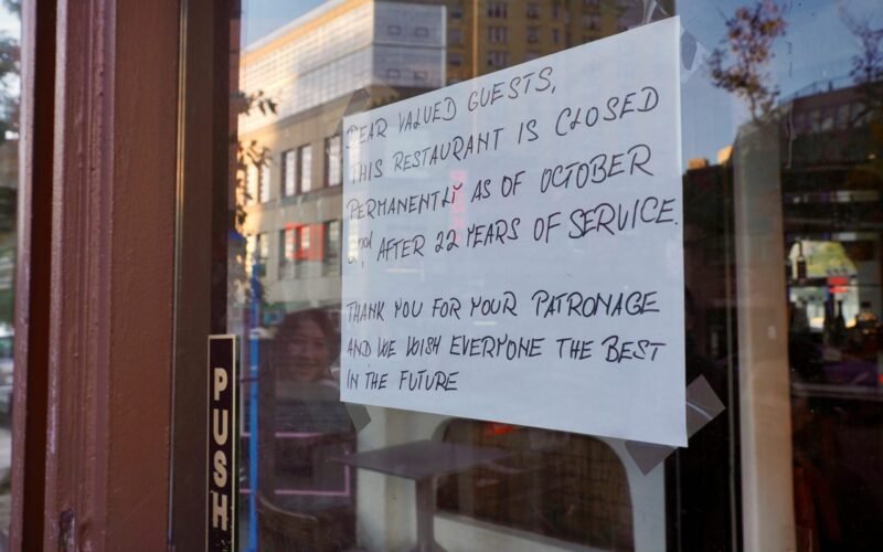 A sign posted on the door of a restaurant