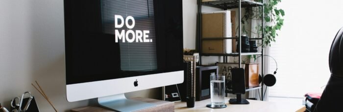 silver iMac with keyboard and trackpad inside room